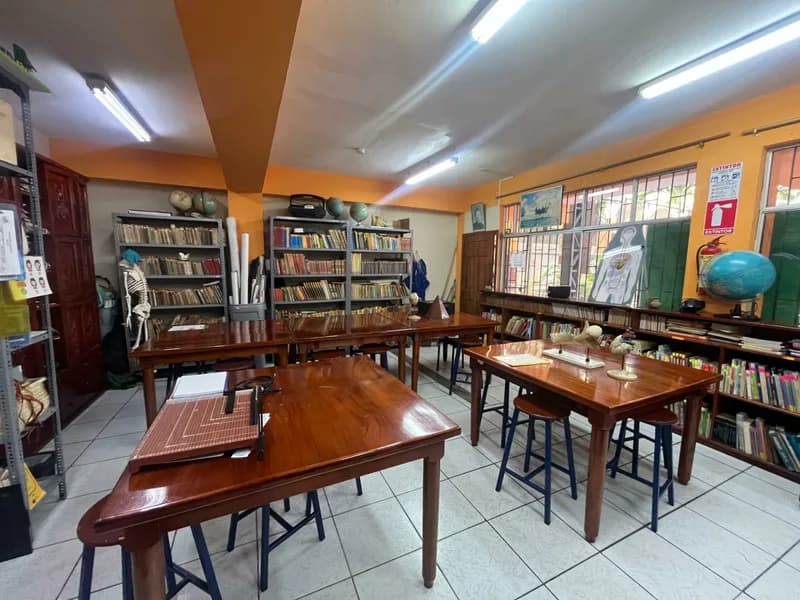 Biblioteca de la institución con estanterías y mesas de lectura