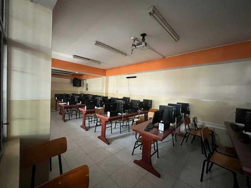 Laboratorio técnico de informática con filas de computadoras de escritorio
